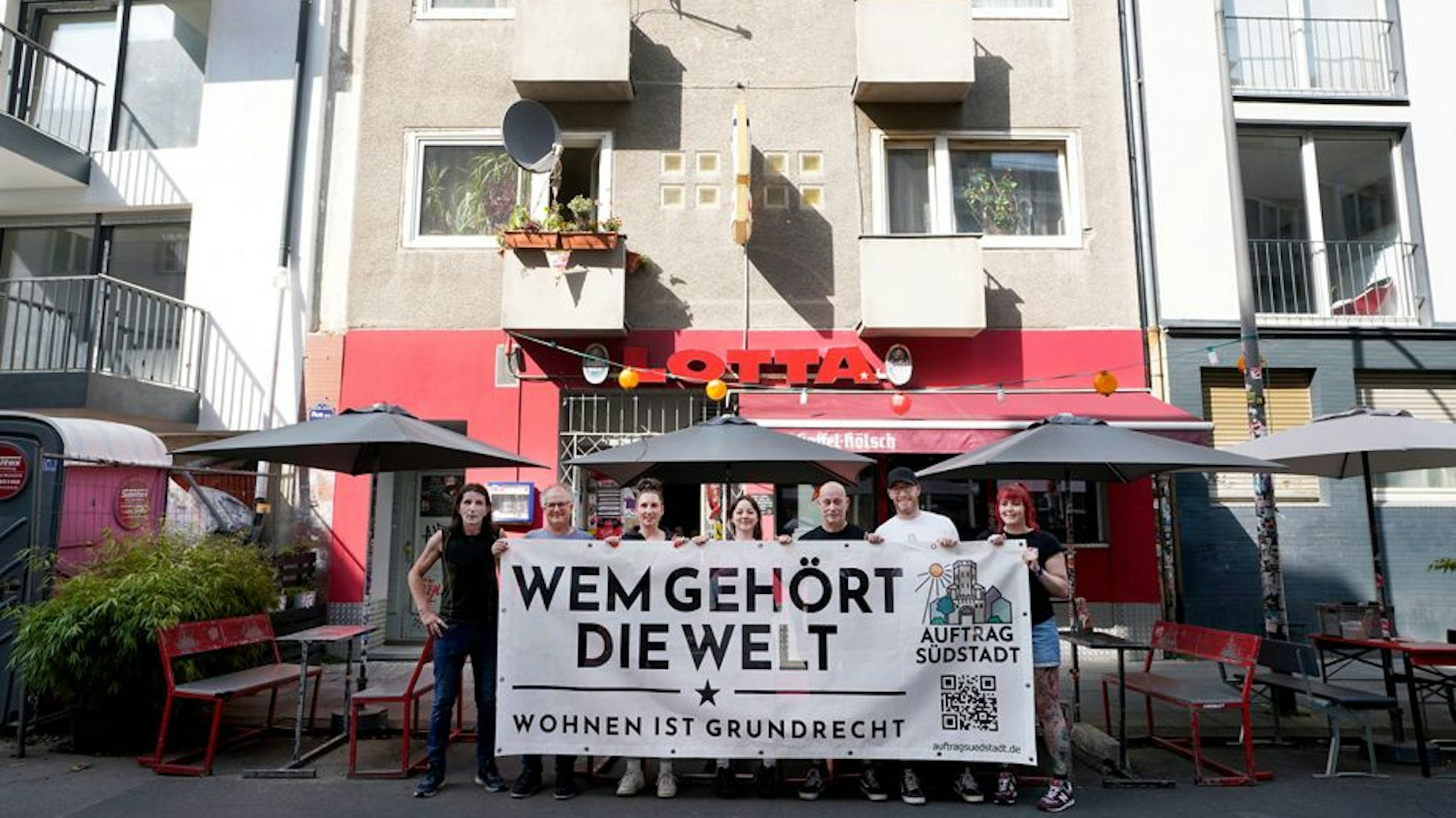 Menschen stehen mit Plakat vor dem Gebäude der Lotta in der Südstadt