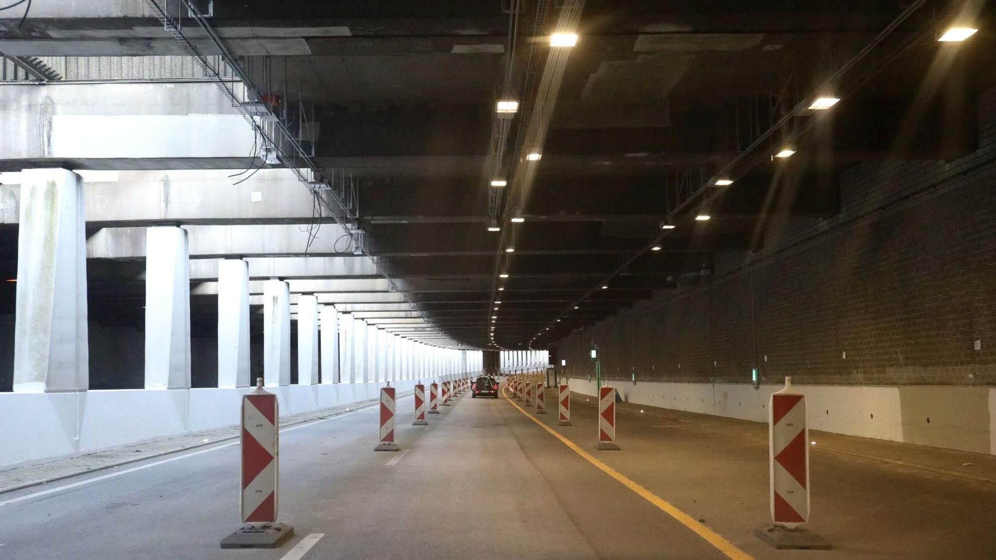 Ein Tunnel mit Warnbaken und Markierungen auf der Fahrbahn.