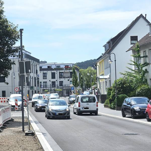 Blick in die neu gestaltete Straße, auf der Autos unterwegs sind.