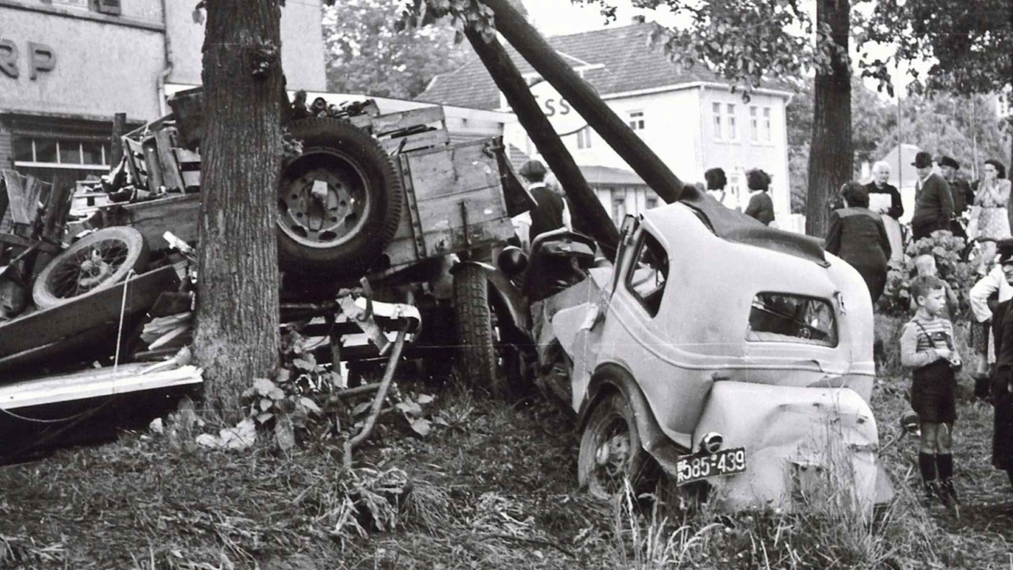 Zwei schwer beschädigte Autos stehen an einem Baum.