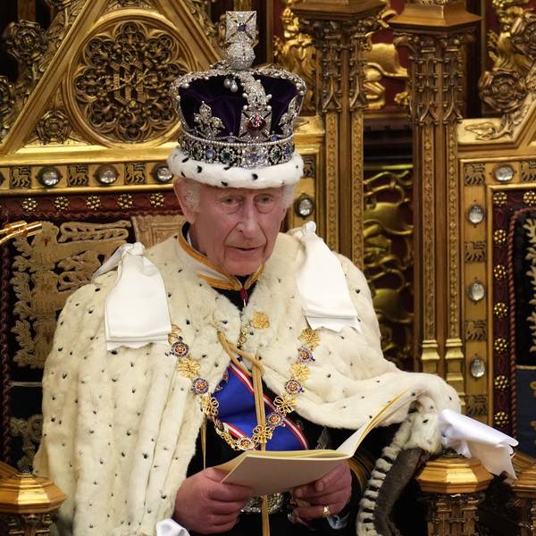 König Charles sitzt auf einem Thron.