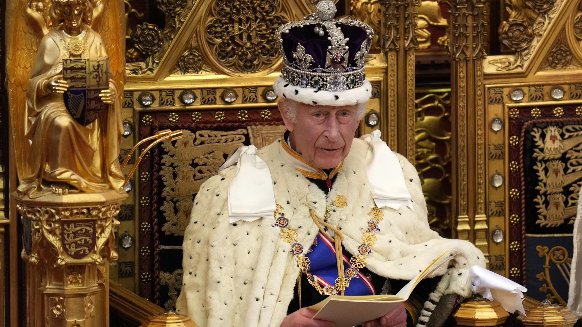 König Charles sitzt auf einem Thron.