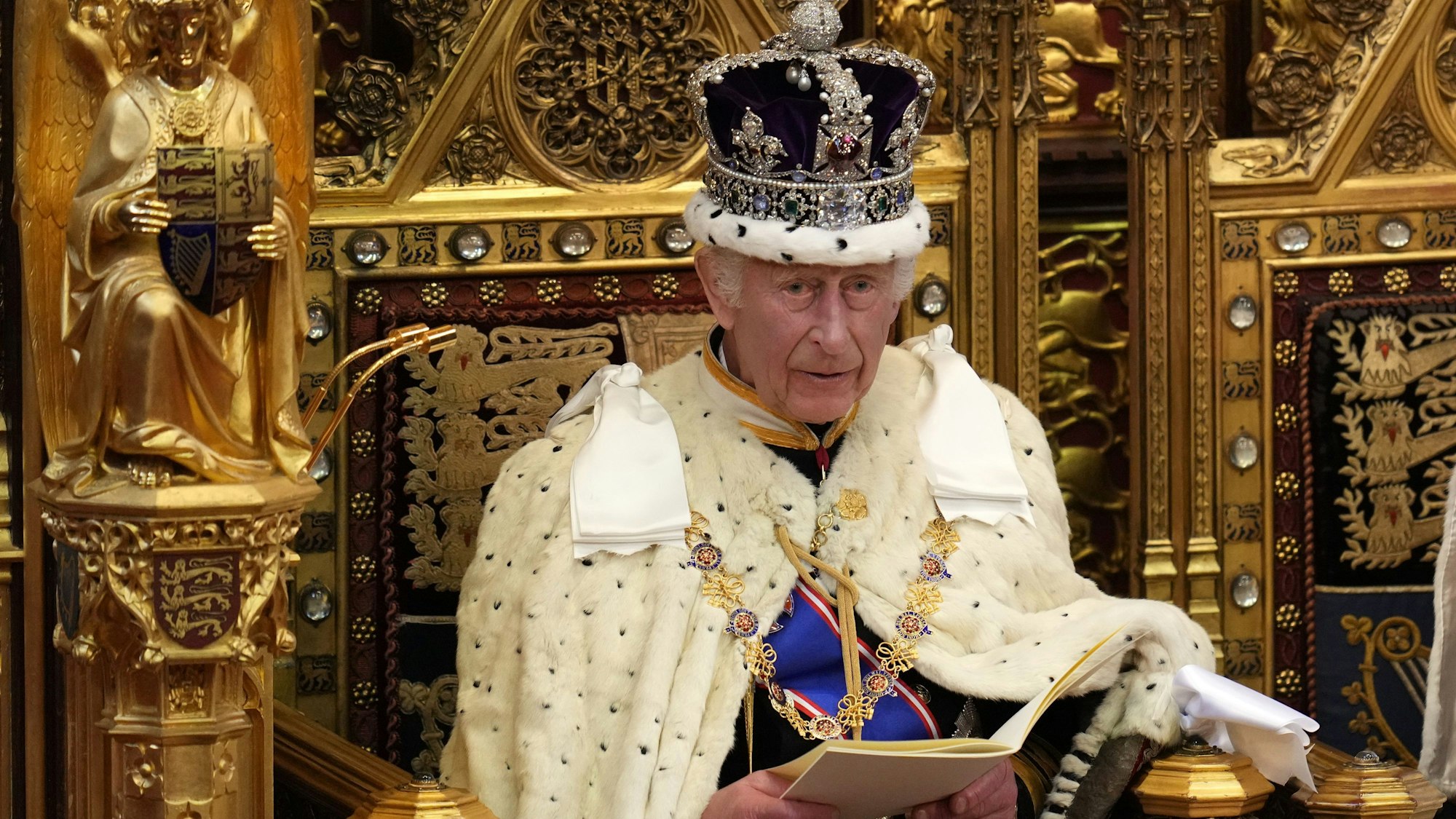 König Charles sitzt auf einem Thron.