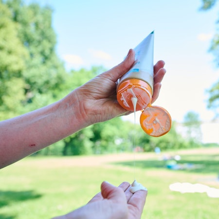 Eine Frau nimmt sich Sonnenmilch aus der Tube.