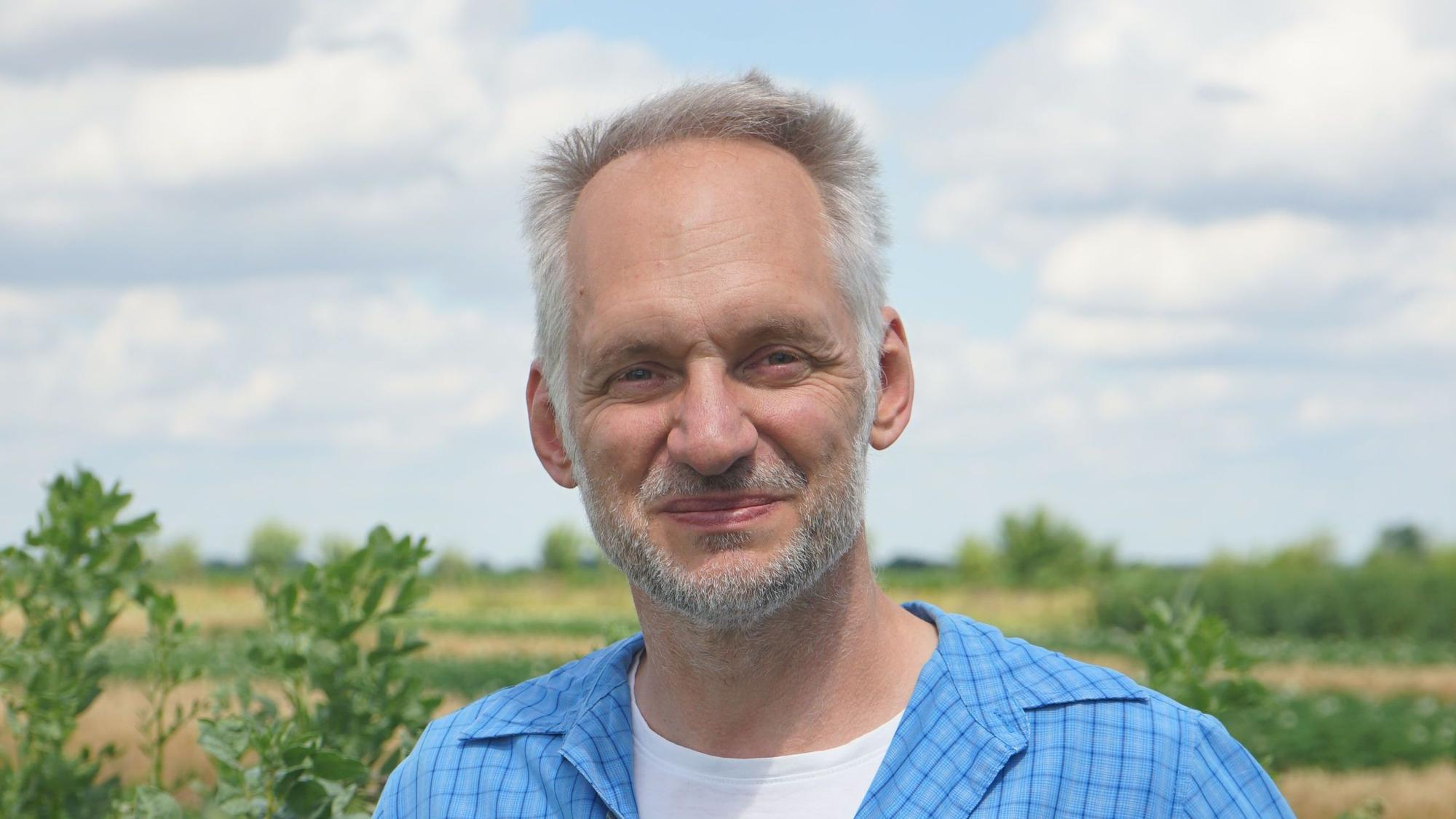 Dr. Gregor Heine vor einem Feld.