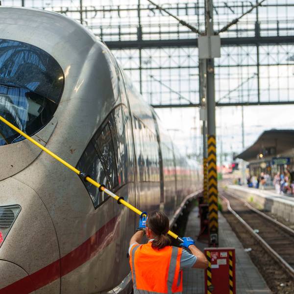 Ein Servicemitarbeiter reinigt im Hauptbahnhof die Frontscheibe eines ICE.