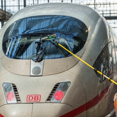 Ein Servicemitarbeiter reinigt im Hauptbahnhof die Frontscheibe eines ICE.