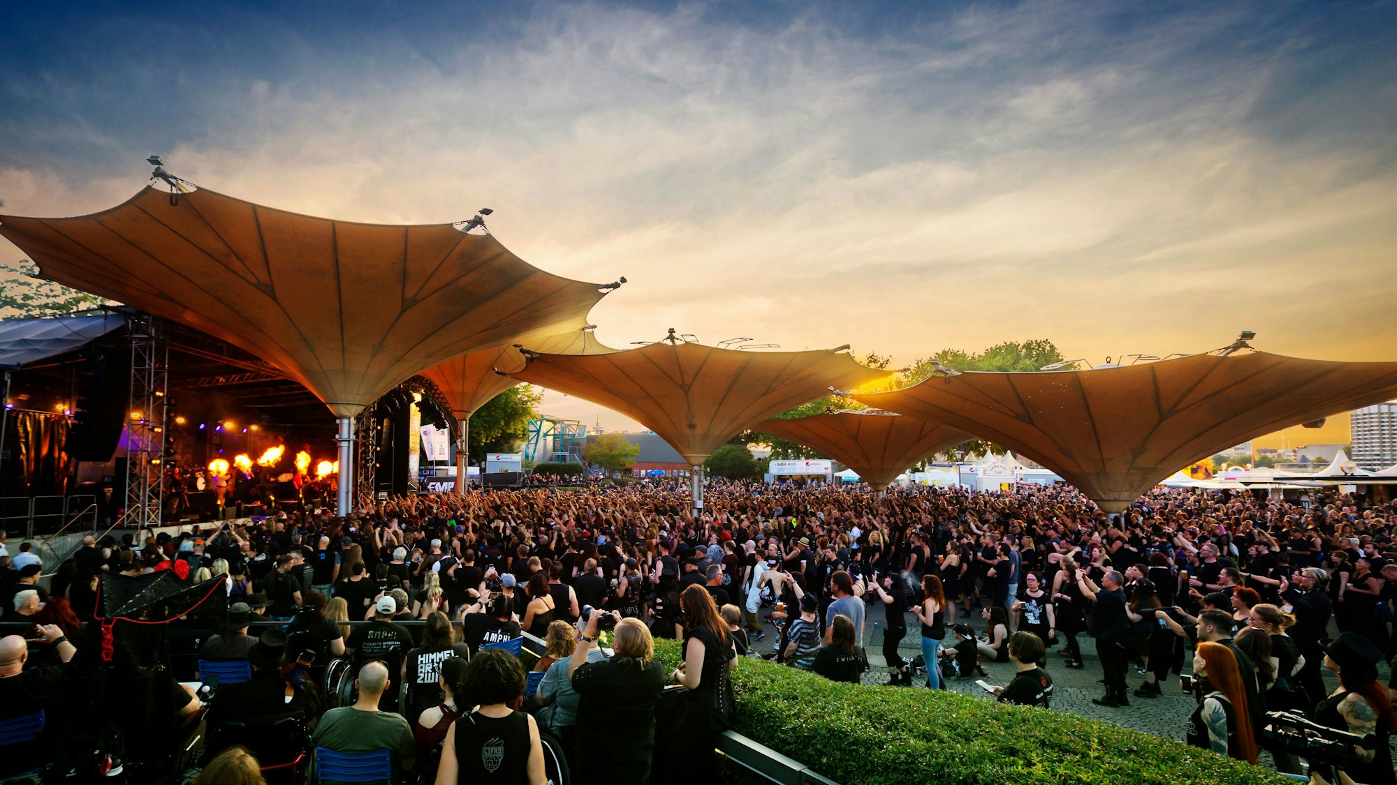 Besucher des Amphi Festivals stehen am Tanzbrunnen.