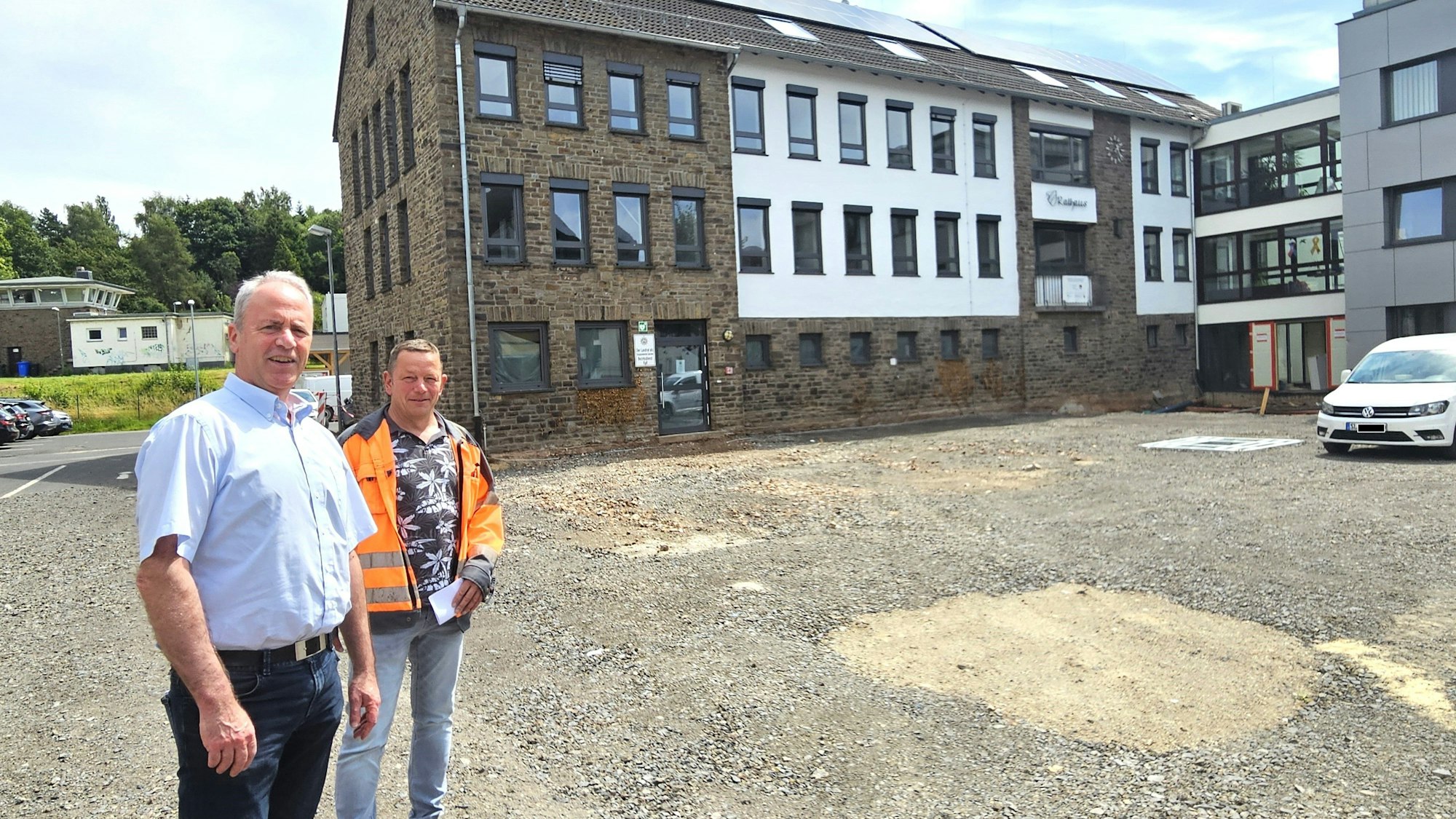 Esser und Margraff stehen auf dem Vorplatz, der noch eine Brachfläche ist. Im Hintergrund das Rathaus.