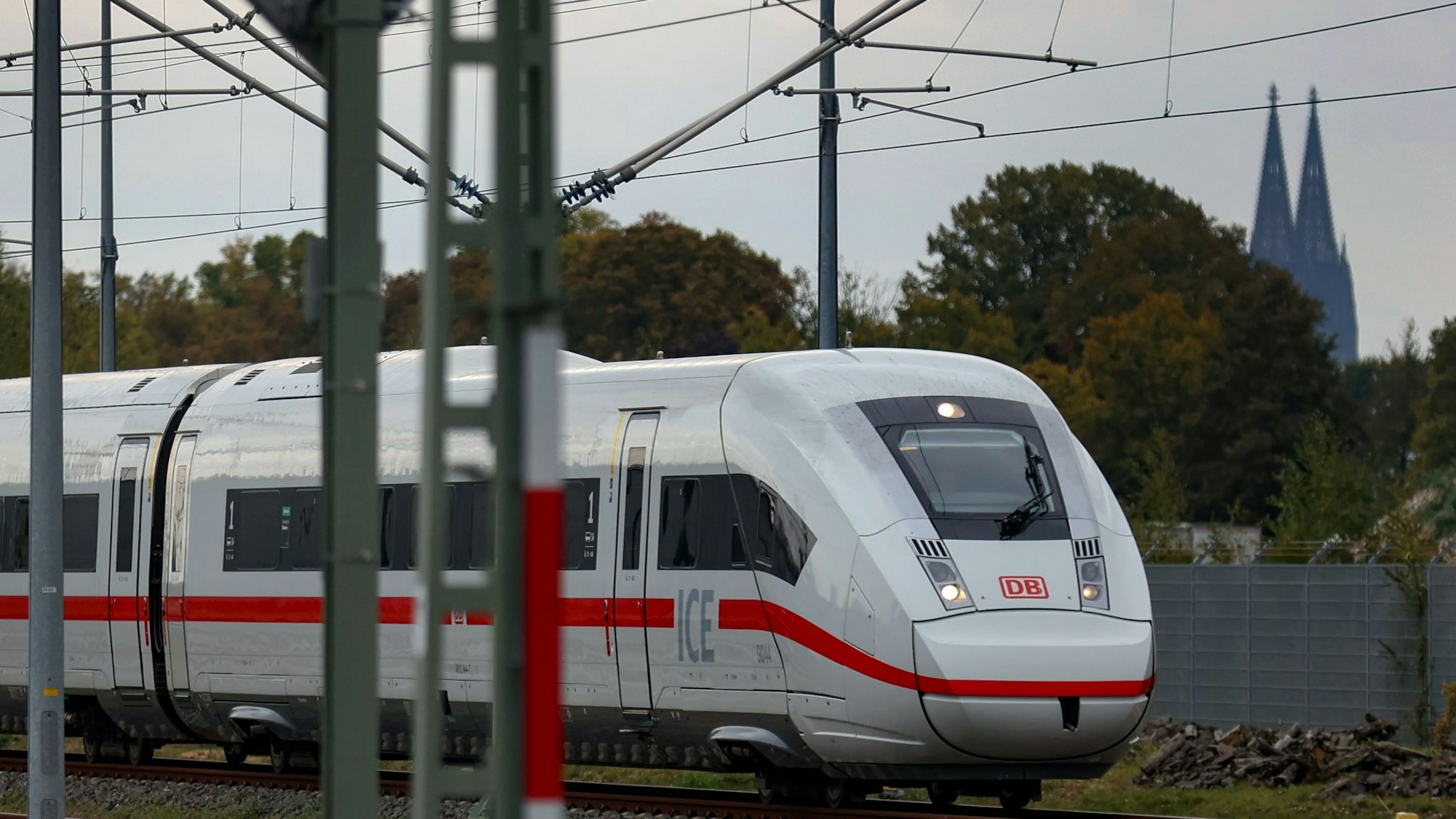 Ein ICE fährt vor dem Kölner Dom über eine Bahnstrecke in Köln.