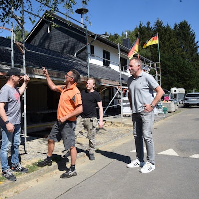 Fünf Männer vor einer Baustelle.