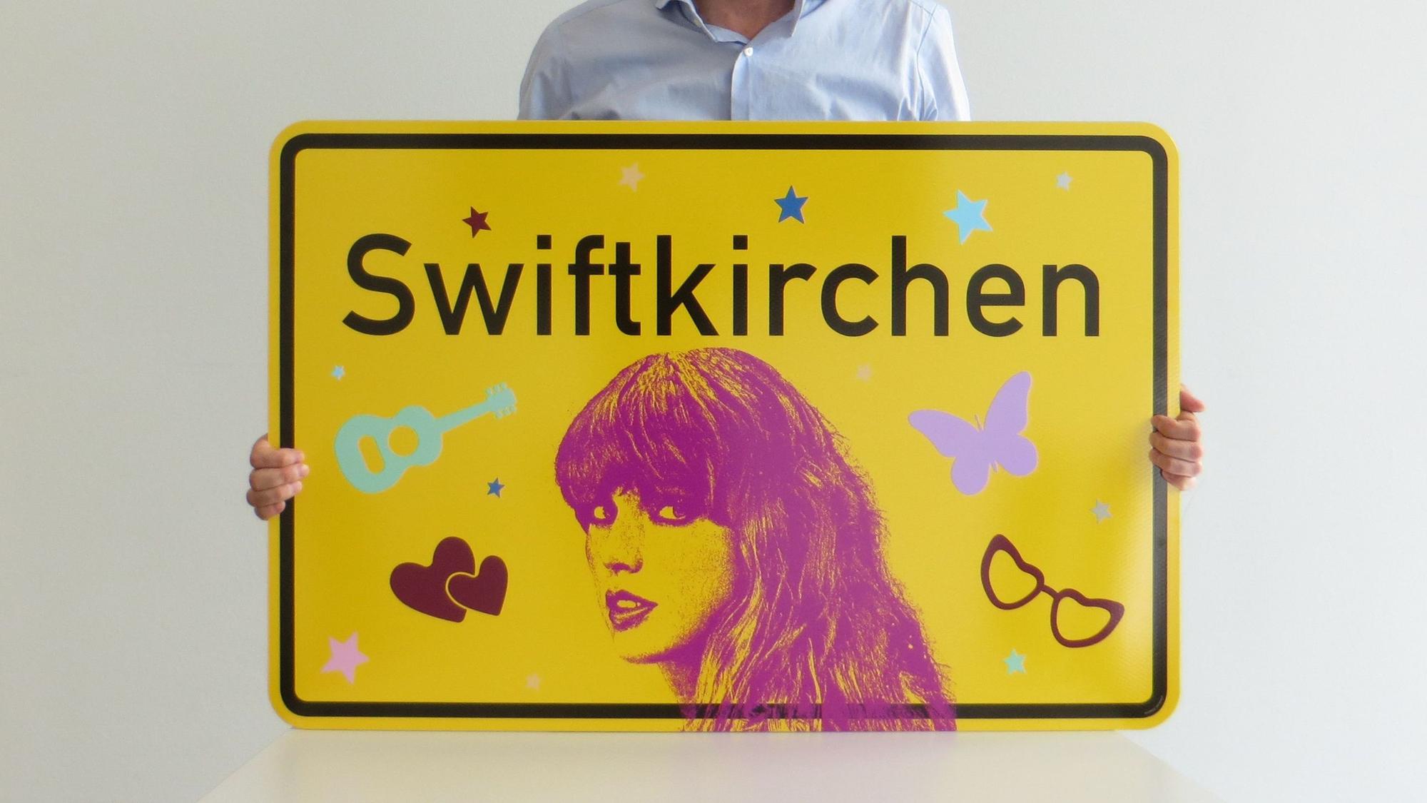 Der Designer und Stadtgrafiker von Gelsenkirchen Uwe Gelesch mit dem von ihm entworfenen Swiftkirchen-Schild