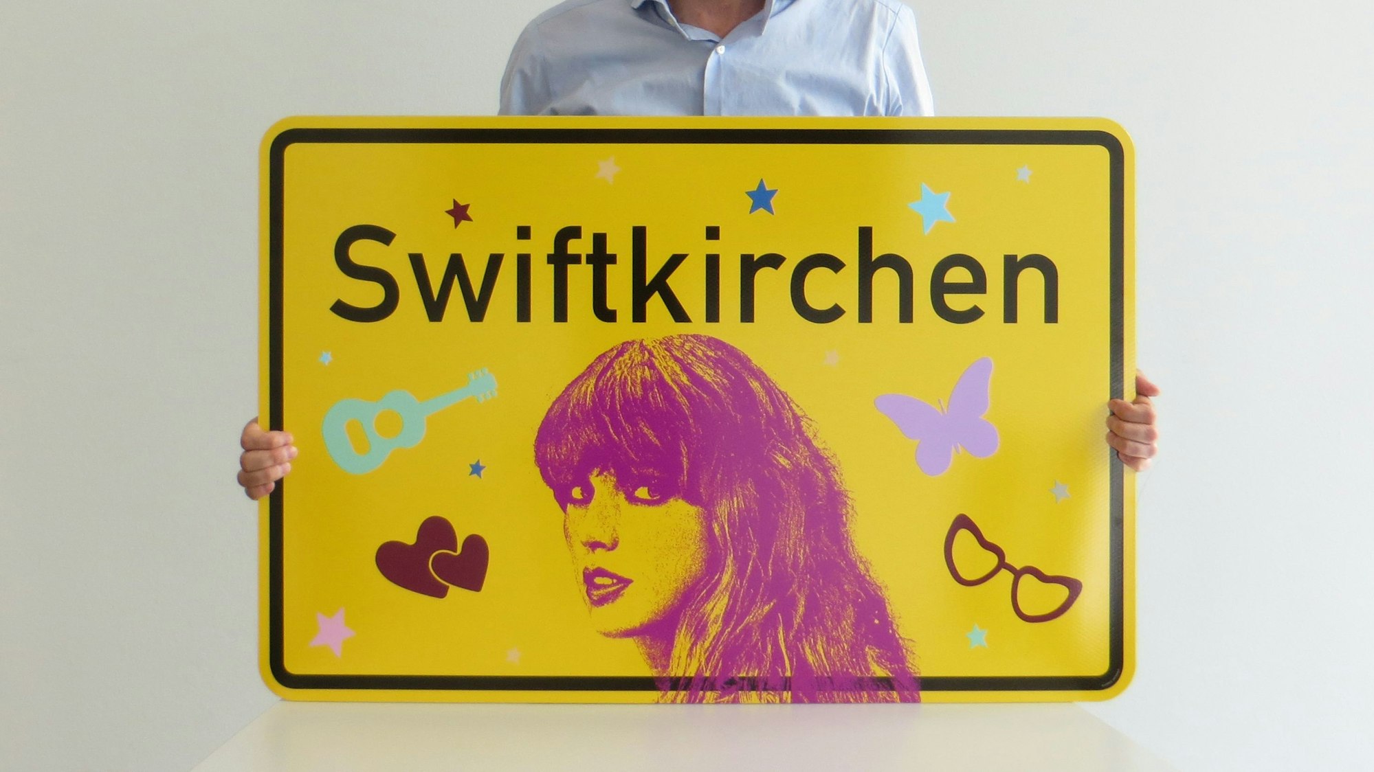 Der Designer und Stadtgrafiker von Gelsenkirchen Uwe Gelesch mit dem von ihm entworfenen Swiftkirchen-Schild