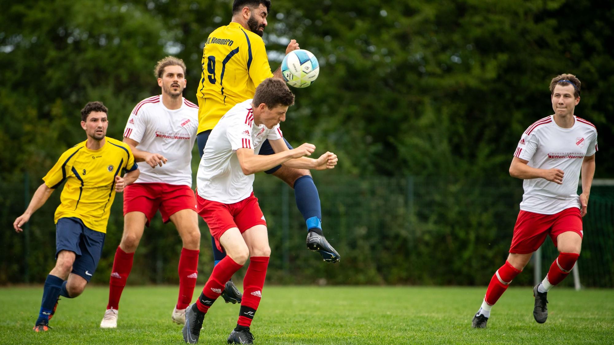 Das Bild zeigt einen Zweikampf nach einem Eckball. Ferhat Alkan springt hoch und klärt den Ball.