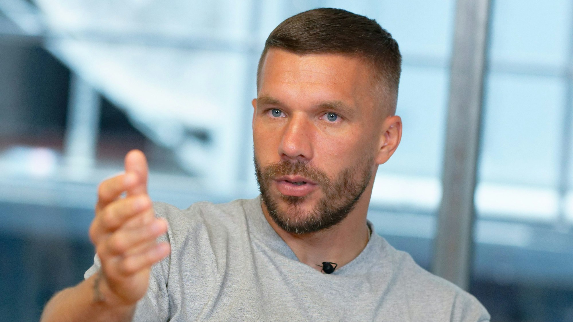 Lukas Podolski, ehemaliger Spieler des 1. FC Köln, gestikuliert während eines Interviews.
