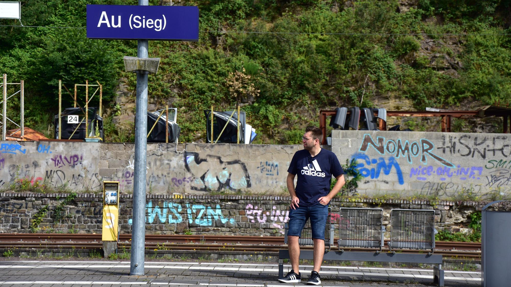 Ein Mann steht auf einem Bahnsteig.