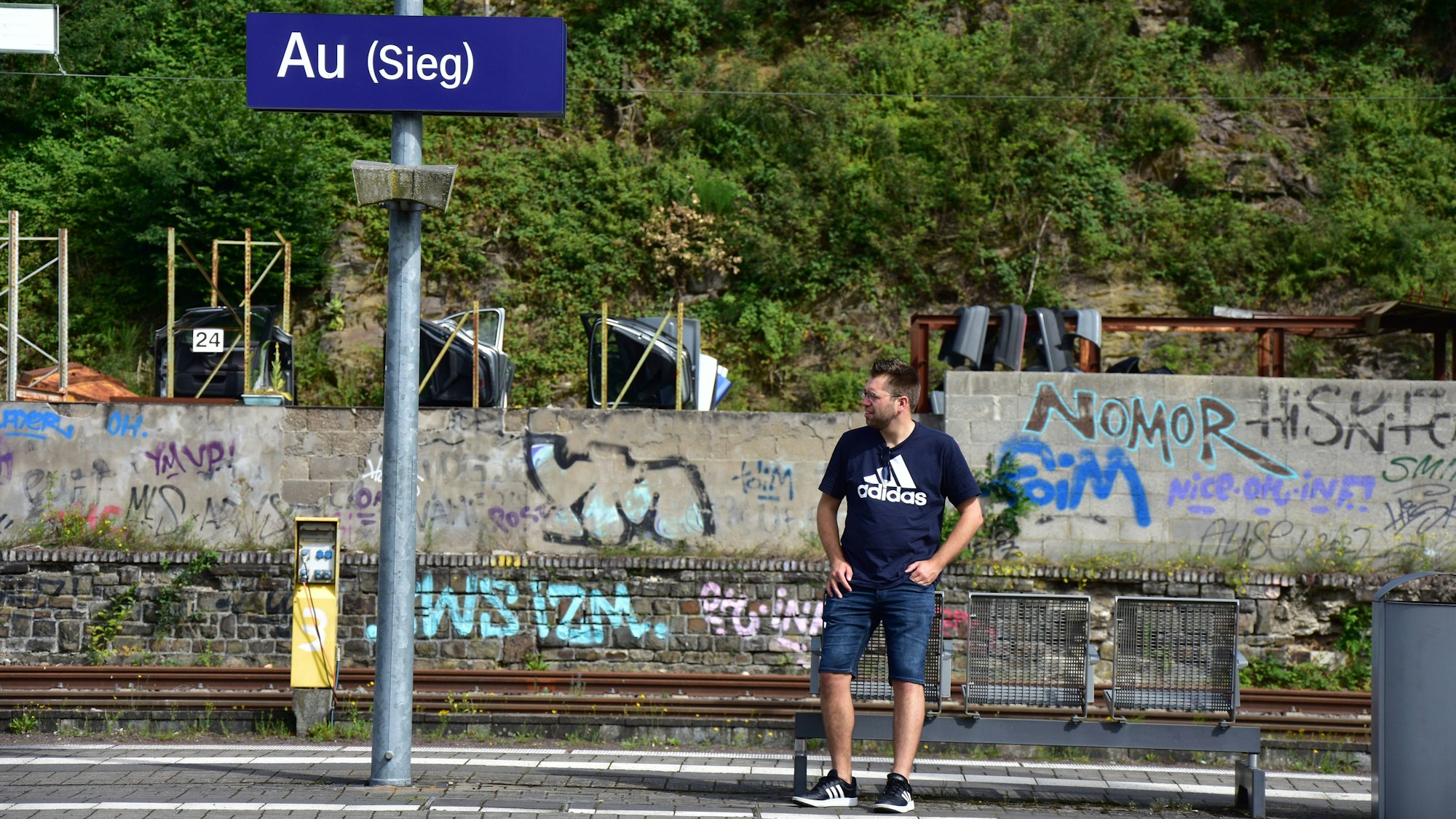 Ein Mann steht auf einem Bahnsteig.