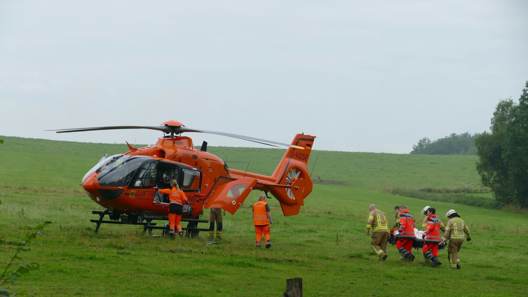 Rettungskräfte tragen eine Patientin zu einem Rettungshubschrauber.