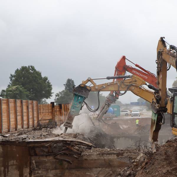 Das Bild zeigt mehrere Bagger, die eine Brücke der A555 bei Wesseling abbaggern.