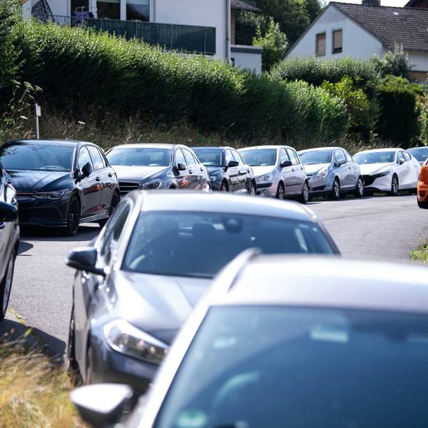 Der Straßenrand ist voll gestellt mit Autos.