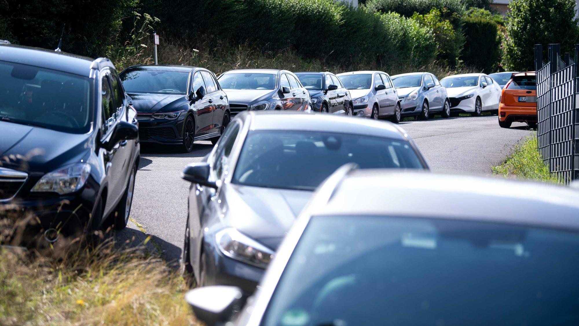 Das Bild zahlreiche geparkte Autos in der Nähe des Sportplatzes.