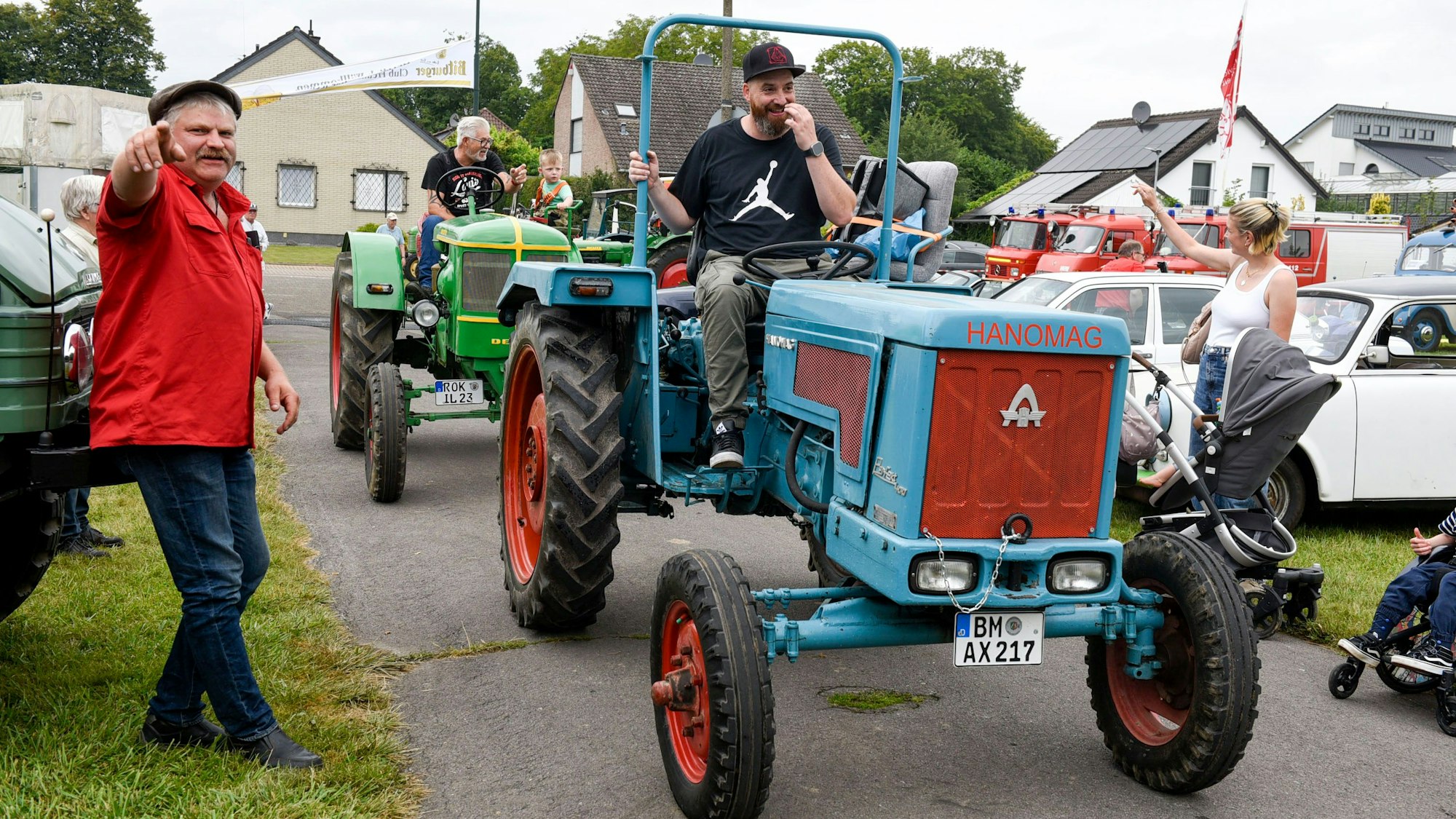 Ein Mann weist den Traktor-Fahrern den Weg.