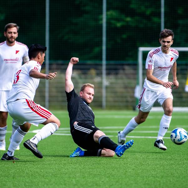 Das Bild zeigt Nierfedls Stürmer Sven Pohl, der den Ball vor drei Gegenspielern weggrätscht.