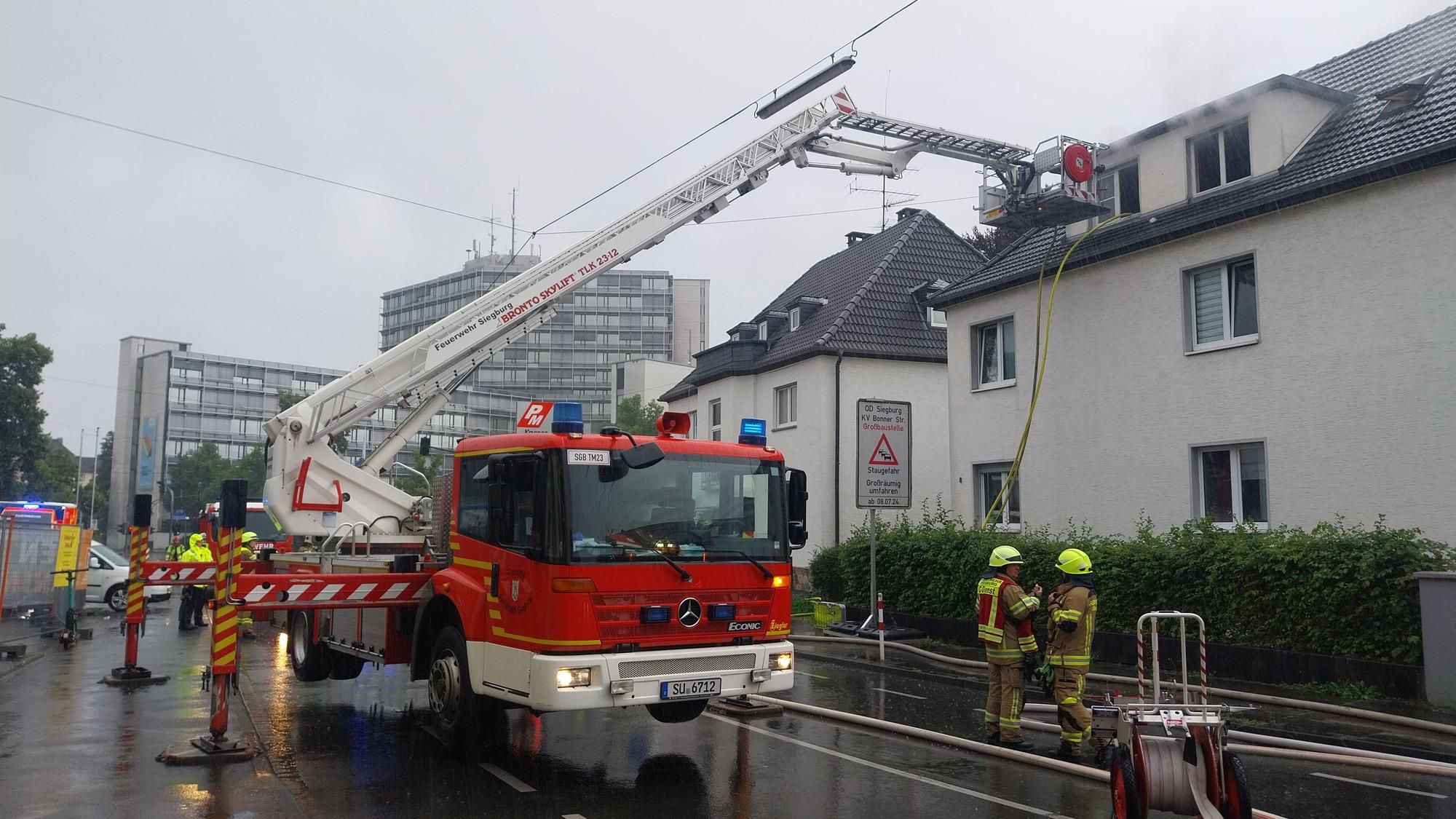 Ein Teleskopmastfahrzeug der Feuerwehr im Einsatz vor einem Haus.