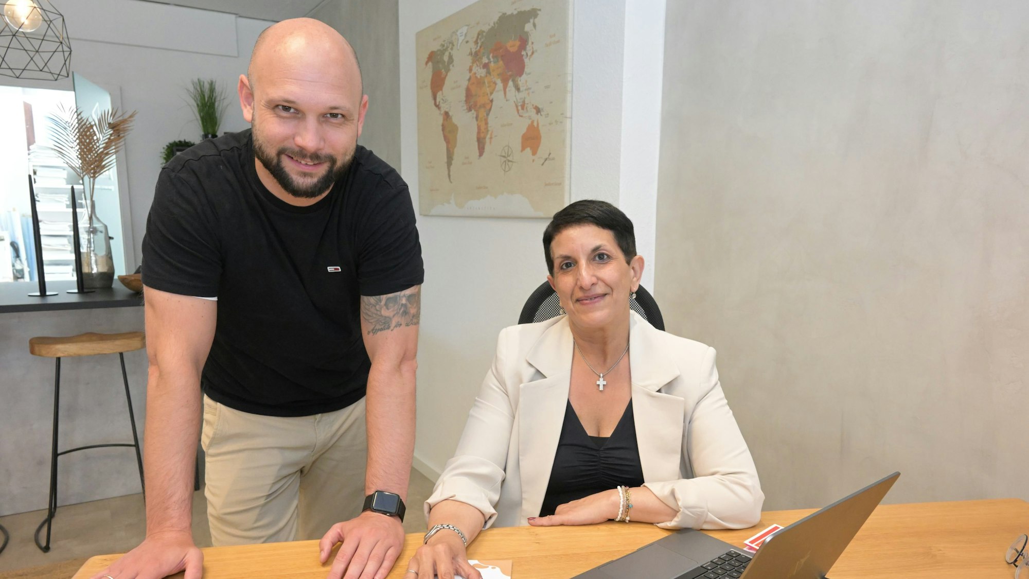 Timo Schumacher und Anna Tese von der „shakebox“ stehen an einem Schreibtisch.