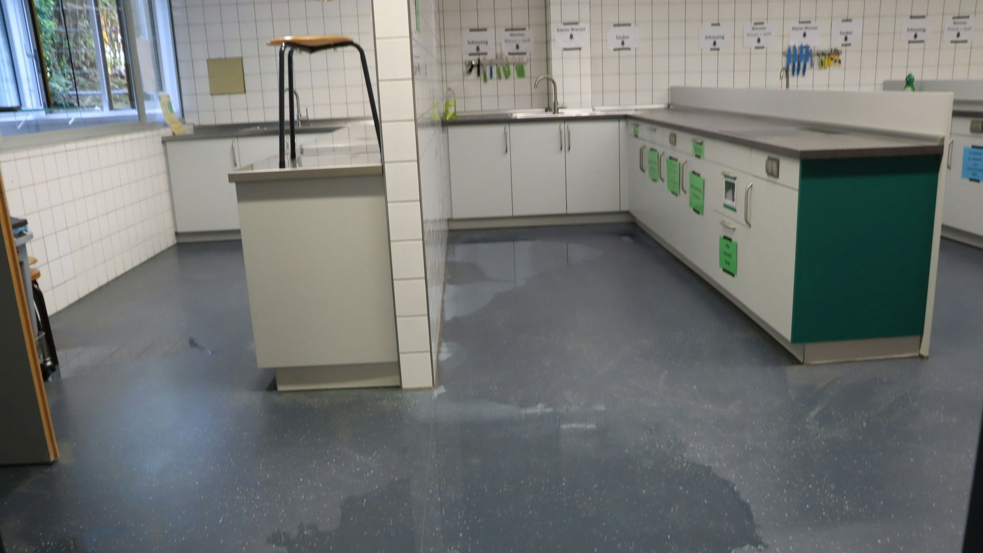 In der Küche einer Schule sind Pfützen auf dem Boden.