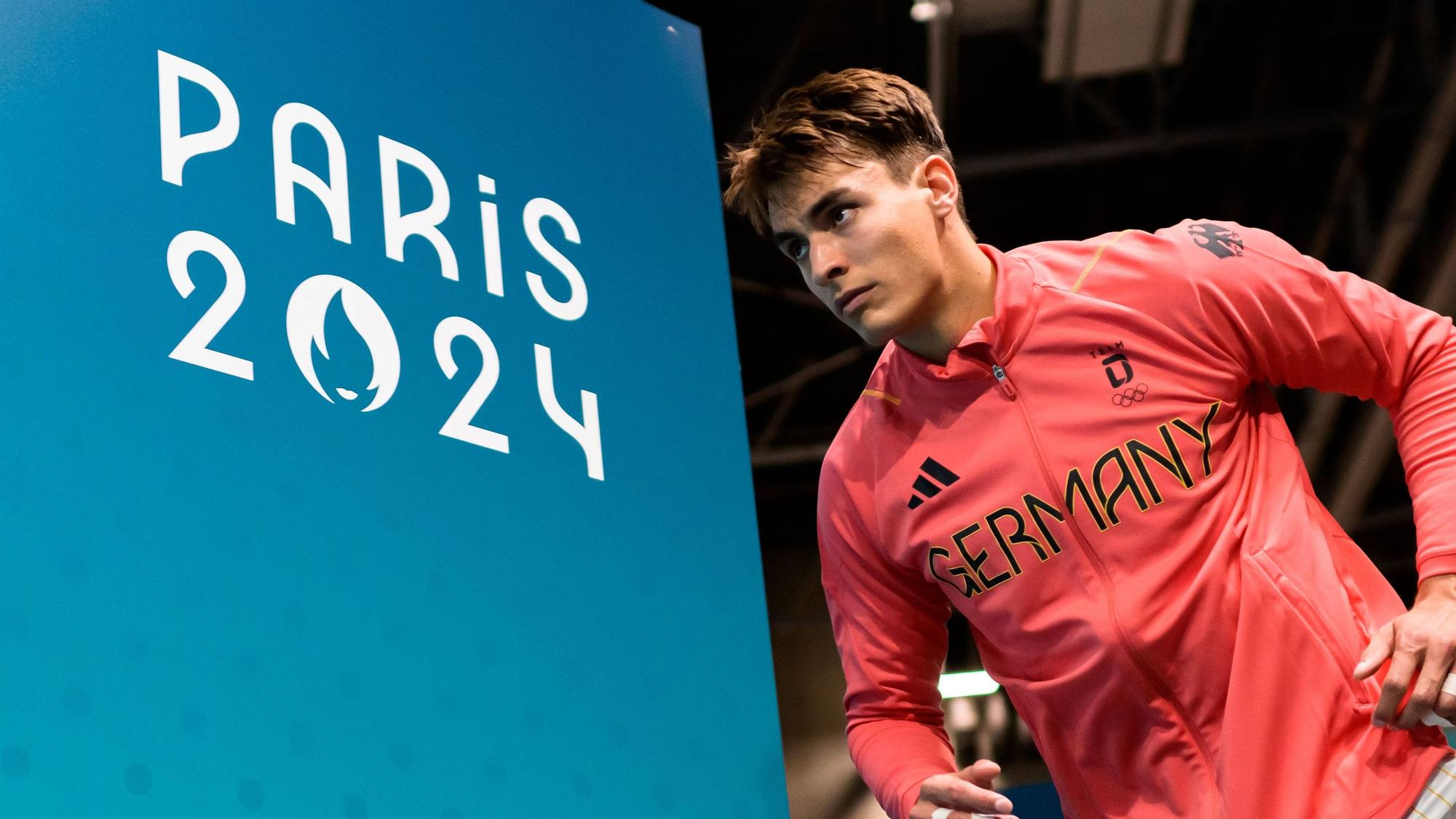 Im Outfit der deutschen Nationalmannschaft läuft Julian Köster vorbei an der Aufschrift Paris 2024 in die Halle ein.