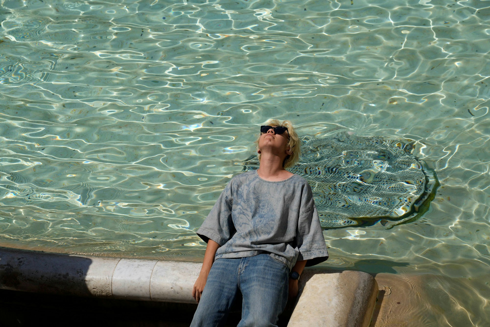 Italien, Rom: Ein Mann sitzt am Trevi-Brunnen. (Symbolbild)