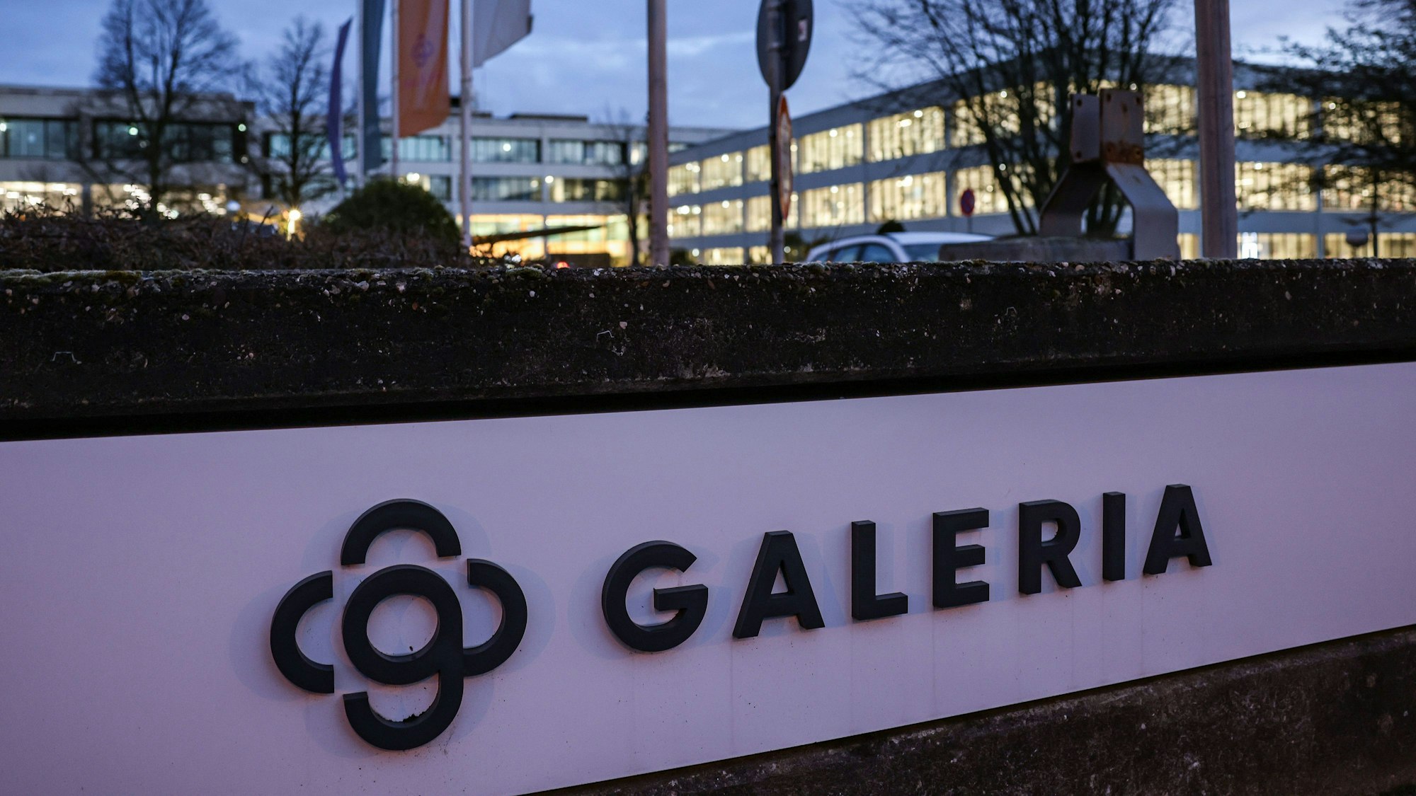 Das Logo des Warenhauskonzerns Galeria Karstadt Kaufhof ist vor der Zentrale beleuchtet.