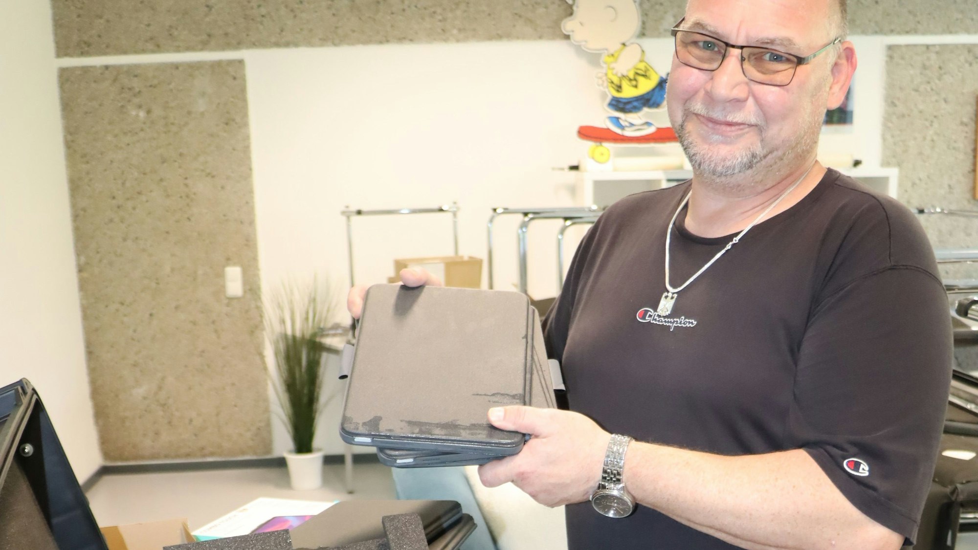 Ein Mann hält Tablets in den Händen.