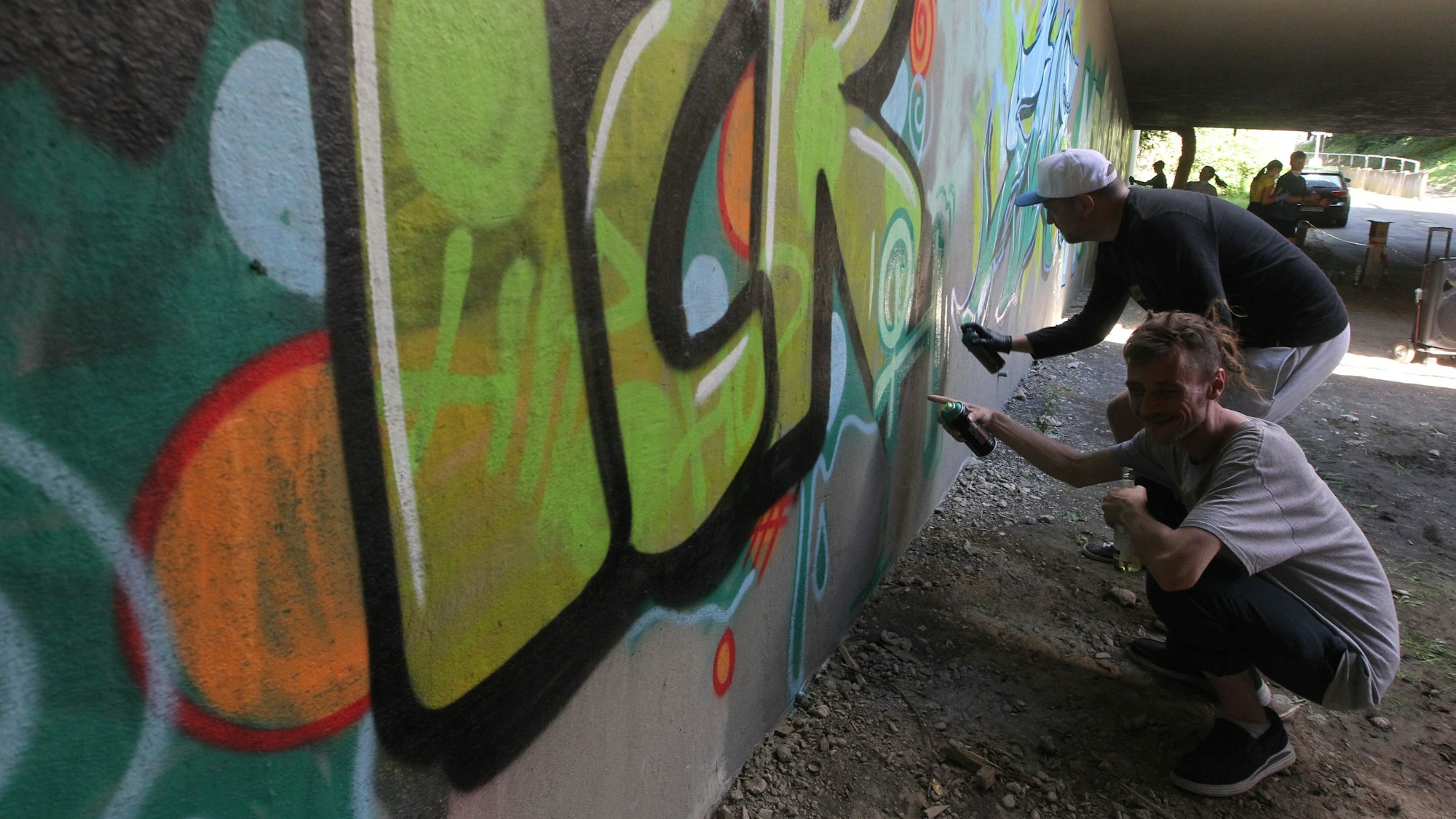 Die Graffiti-Künstler Hendrik (unten) und Markus geben den Kids Tipps.
