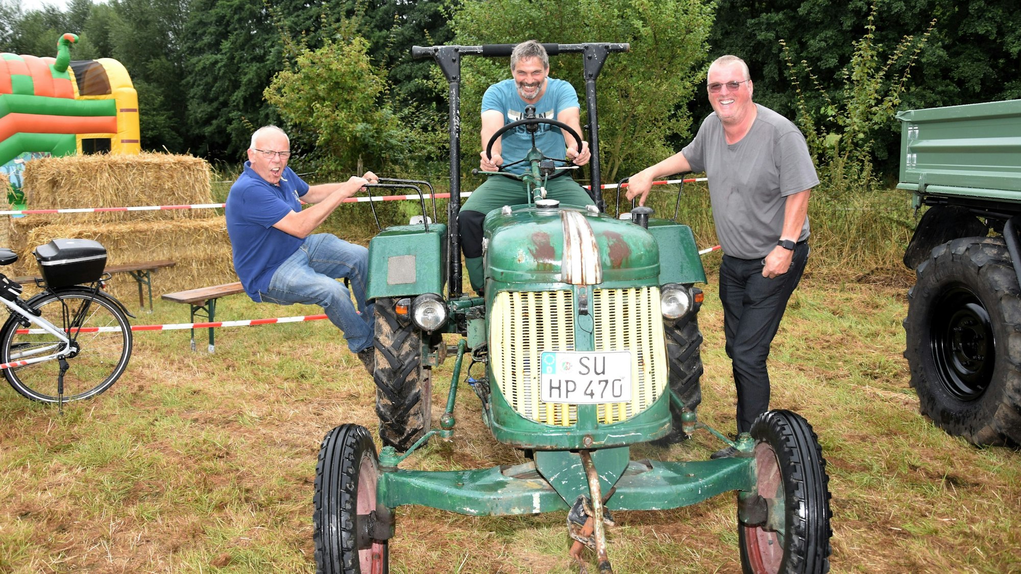 Die beiden Organisatoren Helmut Hartzheim, und Helmut Paterno posieren mit Siegfried Bungardt auf einem ‚Güldner‘ von 1954.