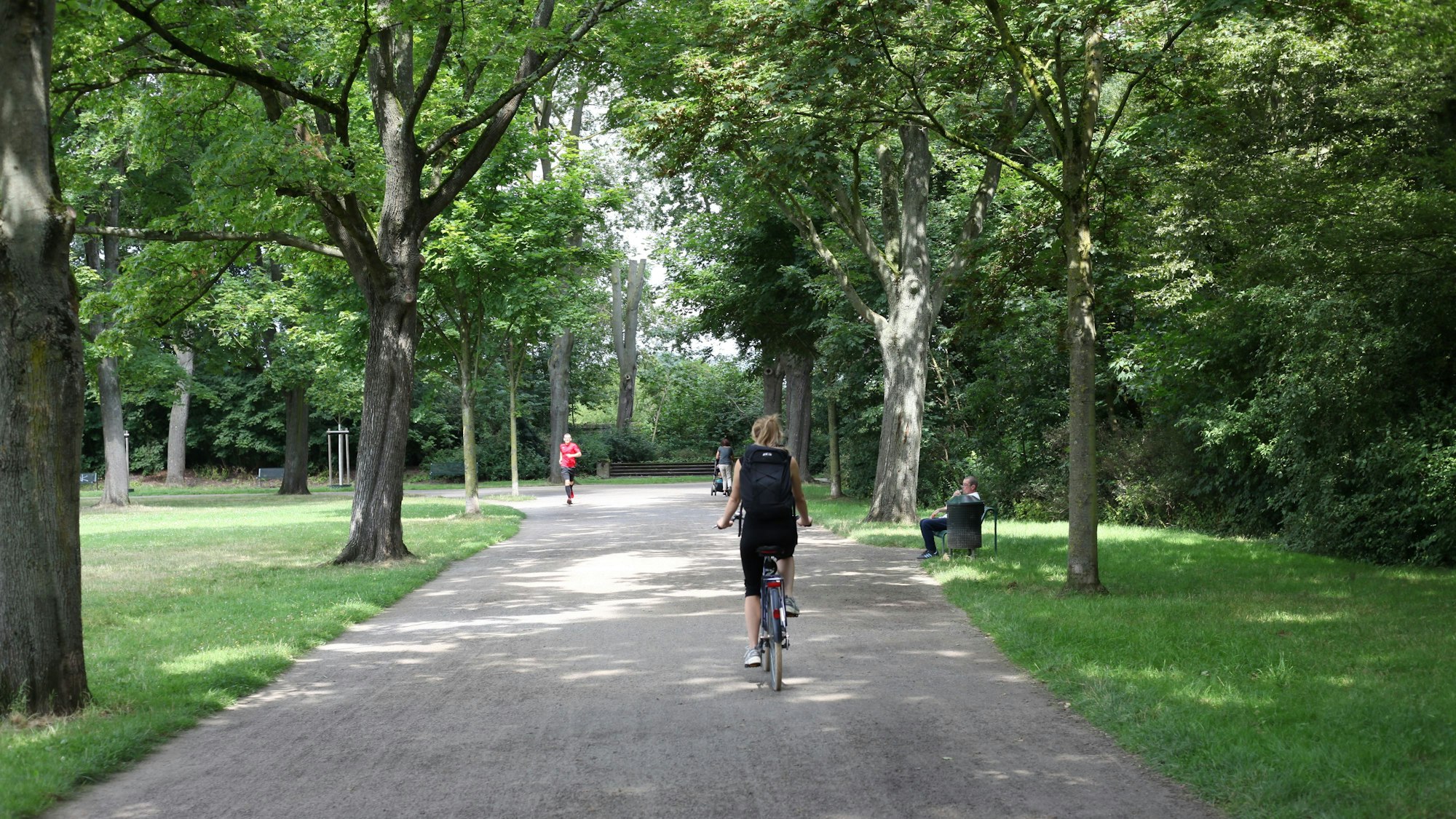 Eine Frau fährt auf einem Rad einen Weg entlang