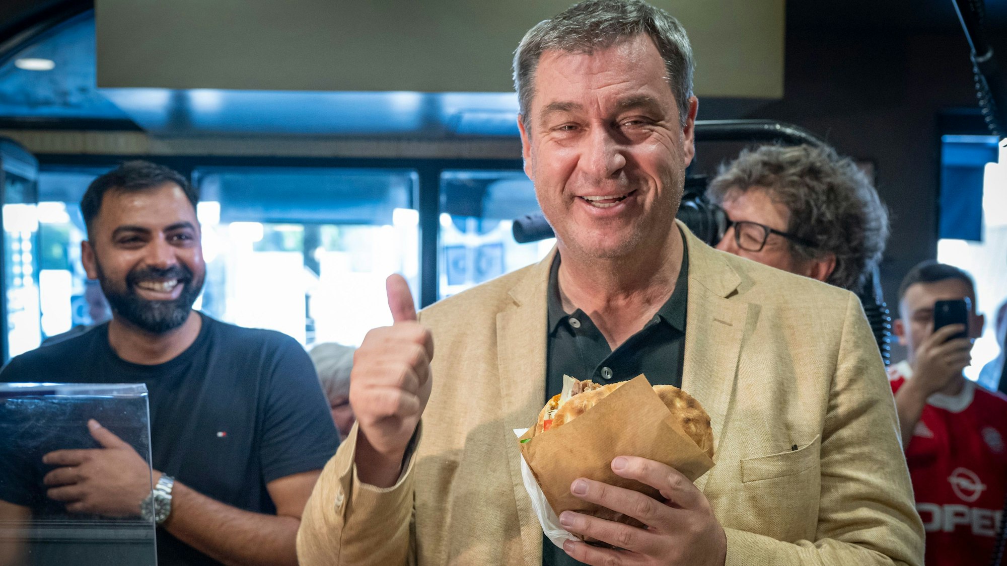 29.07.2024, Bayern, München: Markus Söder (CSU), Ministerpräsident von Bayern, holt sich in einem Dönerlokal einen frischen Döner an der Theke ab.