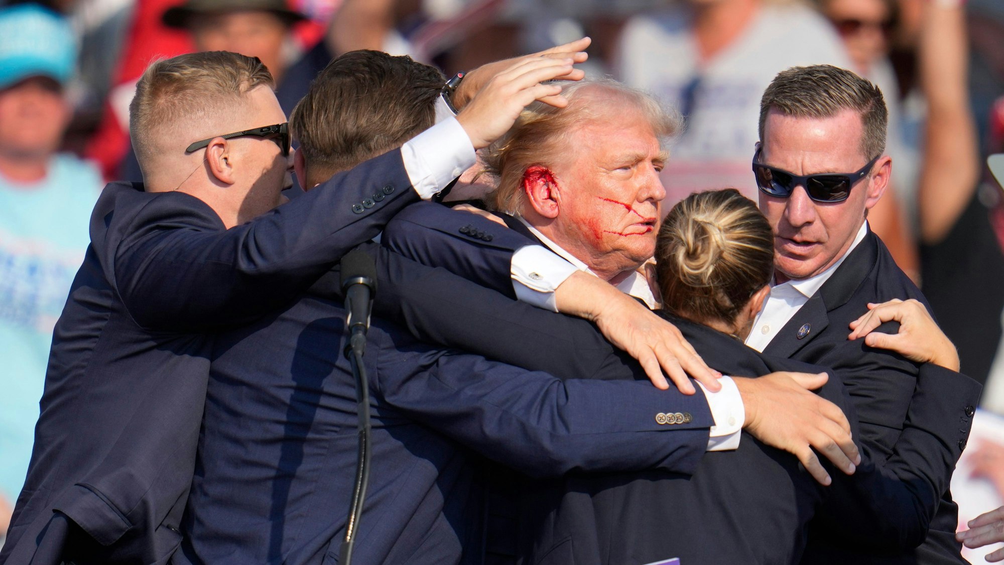 Donald Trump wird von Agenten des US-Geheimdienstes Secret Service umringt, als ihm bei einer Wahlkampfveranstaltung nach einem Attentatversuch von der Bühne geholfen wird.(Archivbild)