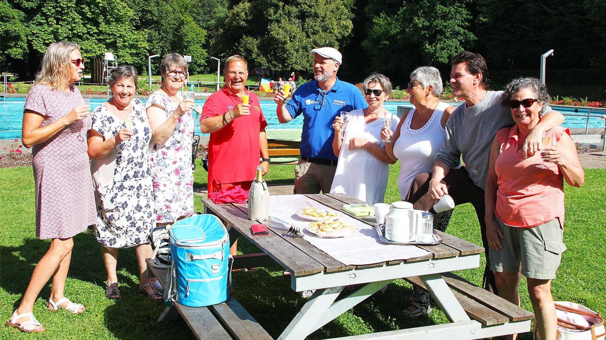 Einige Frauen und Männer haben ein Picknick im Rosenbad in Gemünd aufgebaut und genießen das Freibad-Wetter.