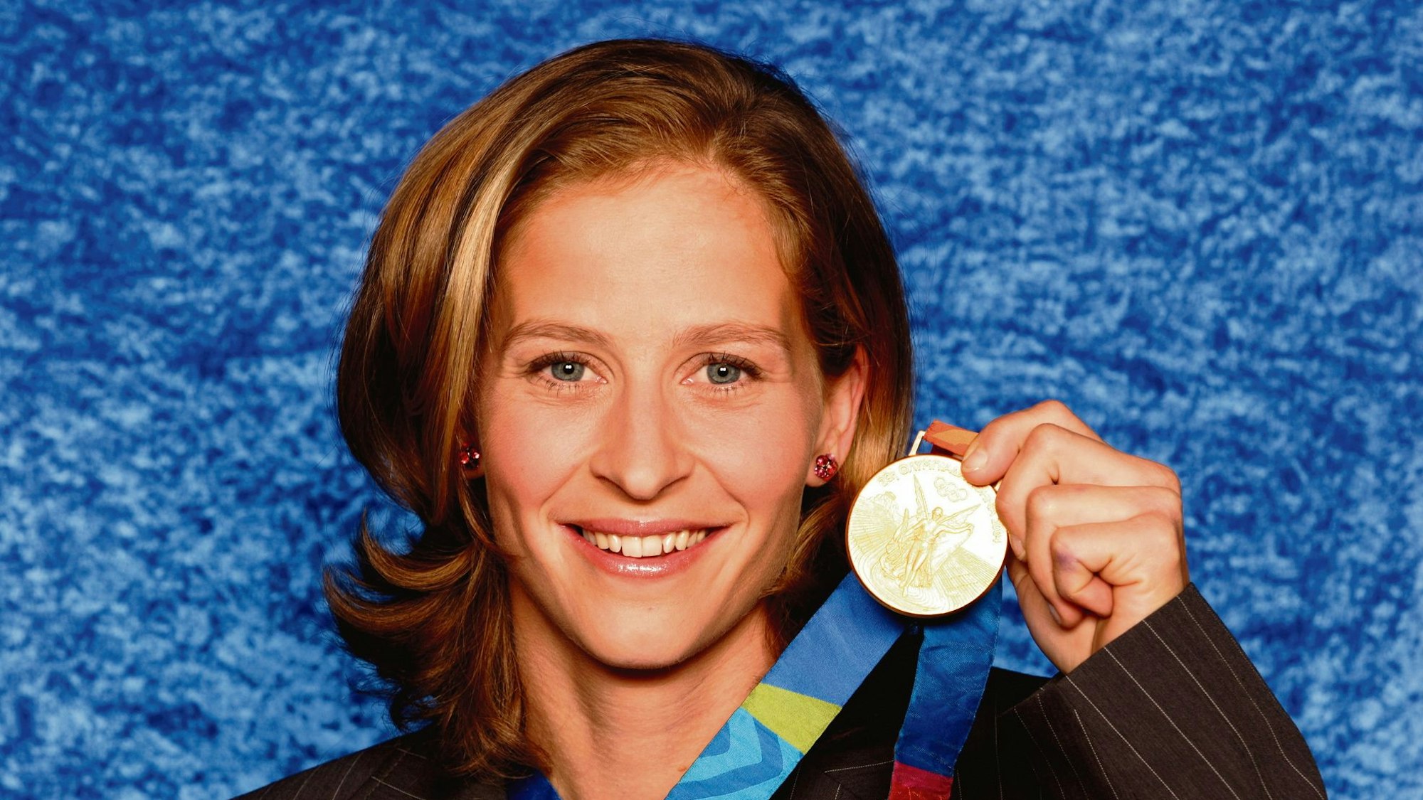 Das Bild zeigt Marion Rodewald mit ihrer Goldmedaille im Jahr 2004.