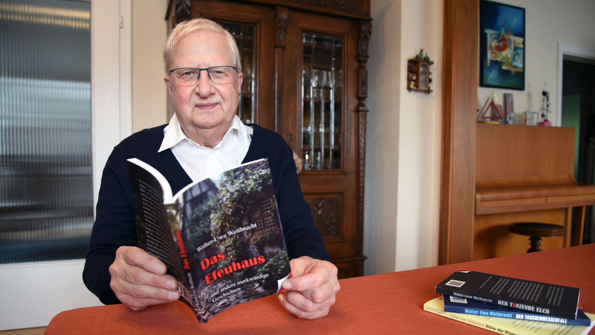 Das Foto zeigt den Autor Walter-Uwe Weitbrecht, in den Händen hält er sein neues Buch mit dem Titel "Das Efeuhaus" .