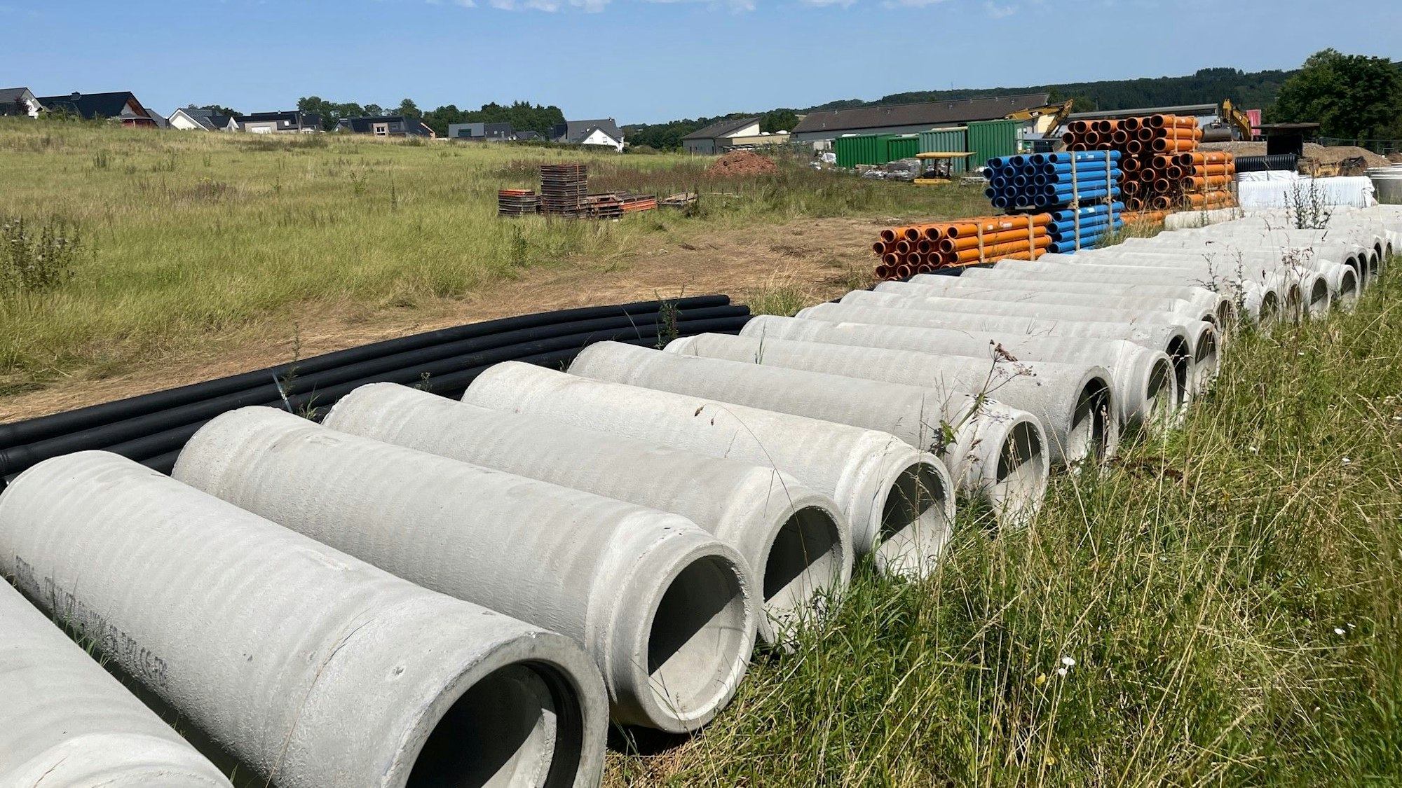 Kanalrohre liegen eng aneinander auf einem Feld.