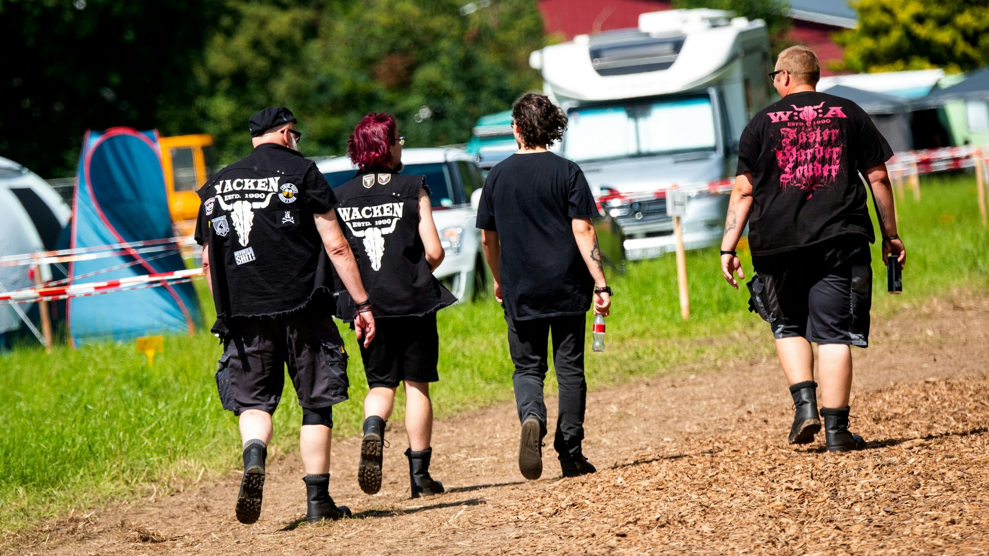 Besucher vom Heavy-Metal-Festival Wacken Open Air (W:O:A) gehen über einen Campingplatz. (Archivbild)