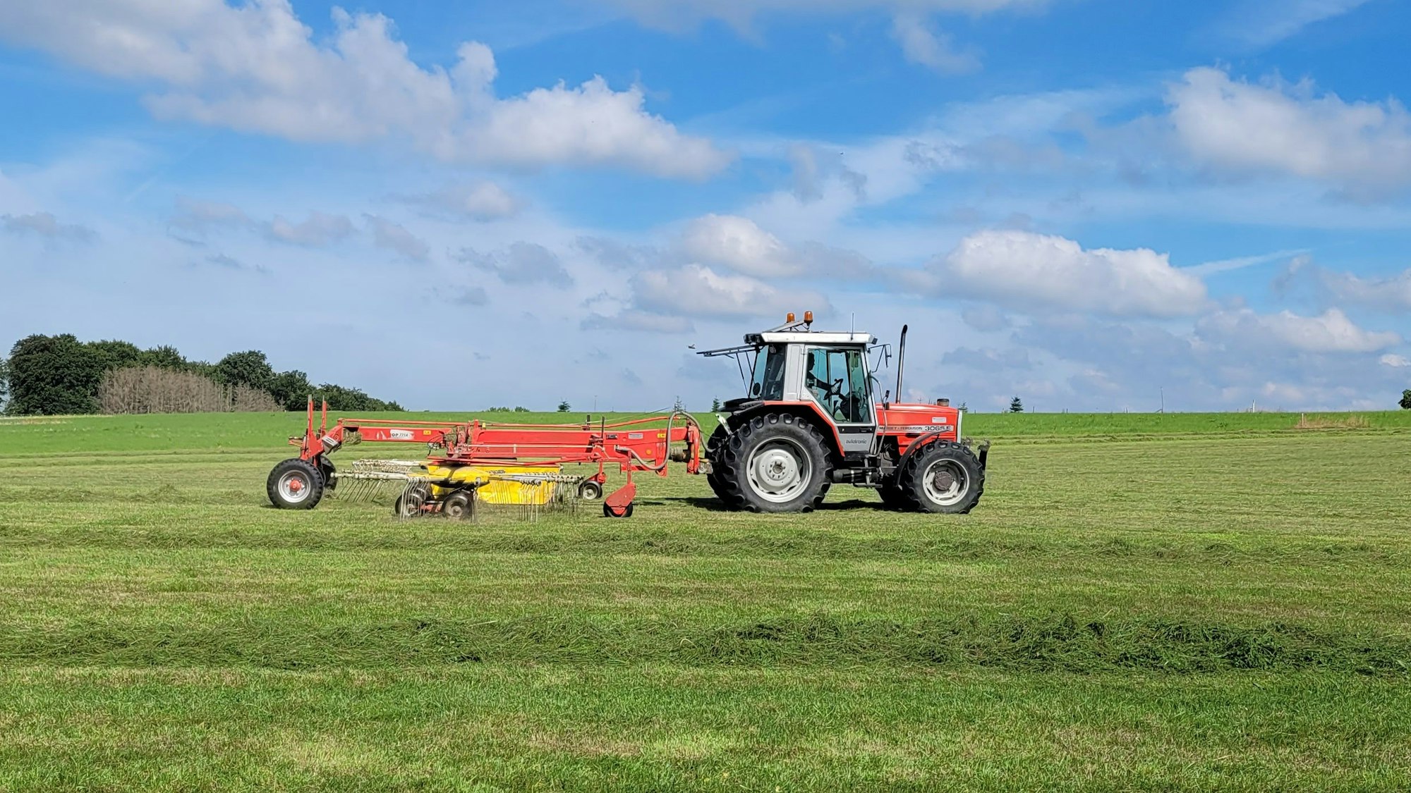 Ein Traktor fährt über eine Wiese.