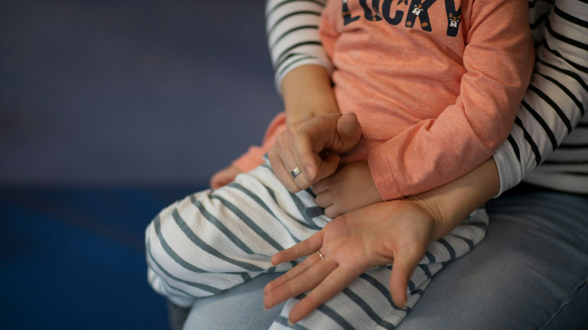 Ein Kind sitzt auf dem Schoß einer Frau.