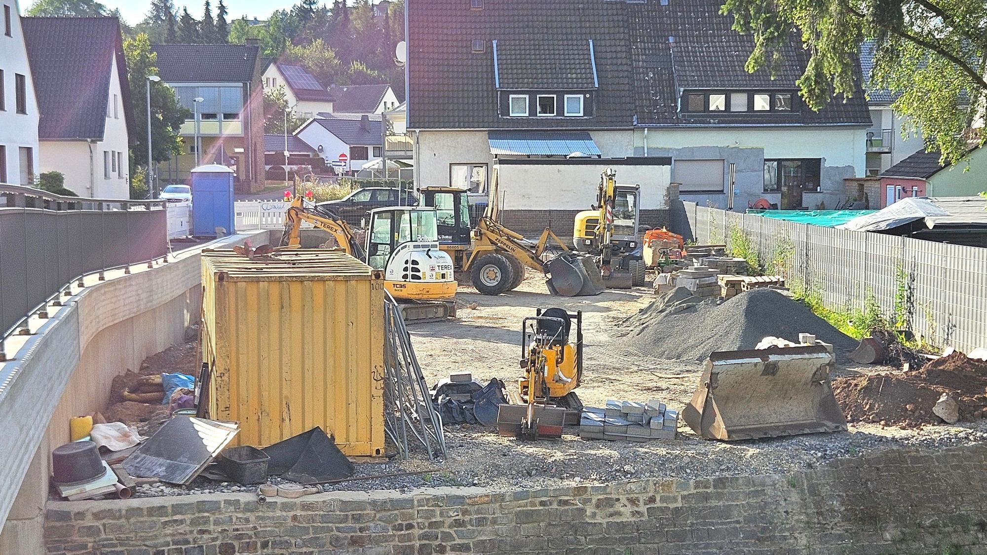 Blick auf den Parkplatz, auf dem verschiedene Baufahrzeuge stehen.