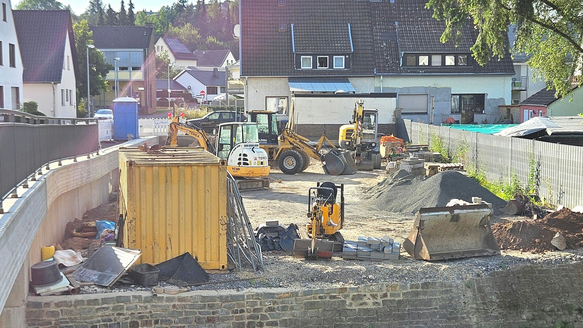 Blick auf den Parkplatz, auf dem verschiedene Baufahrzeuge stehen.