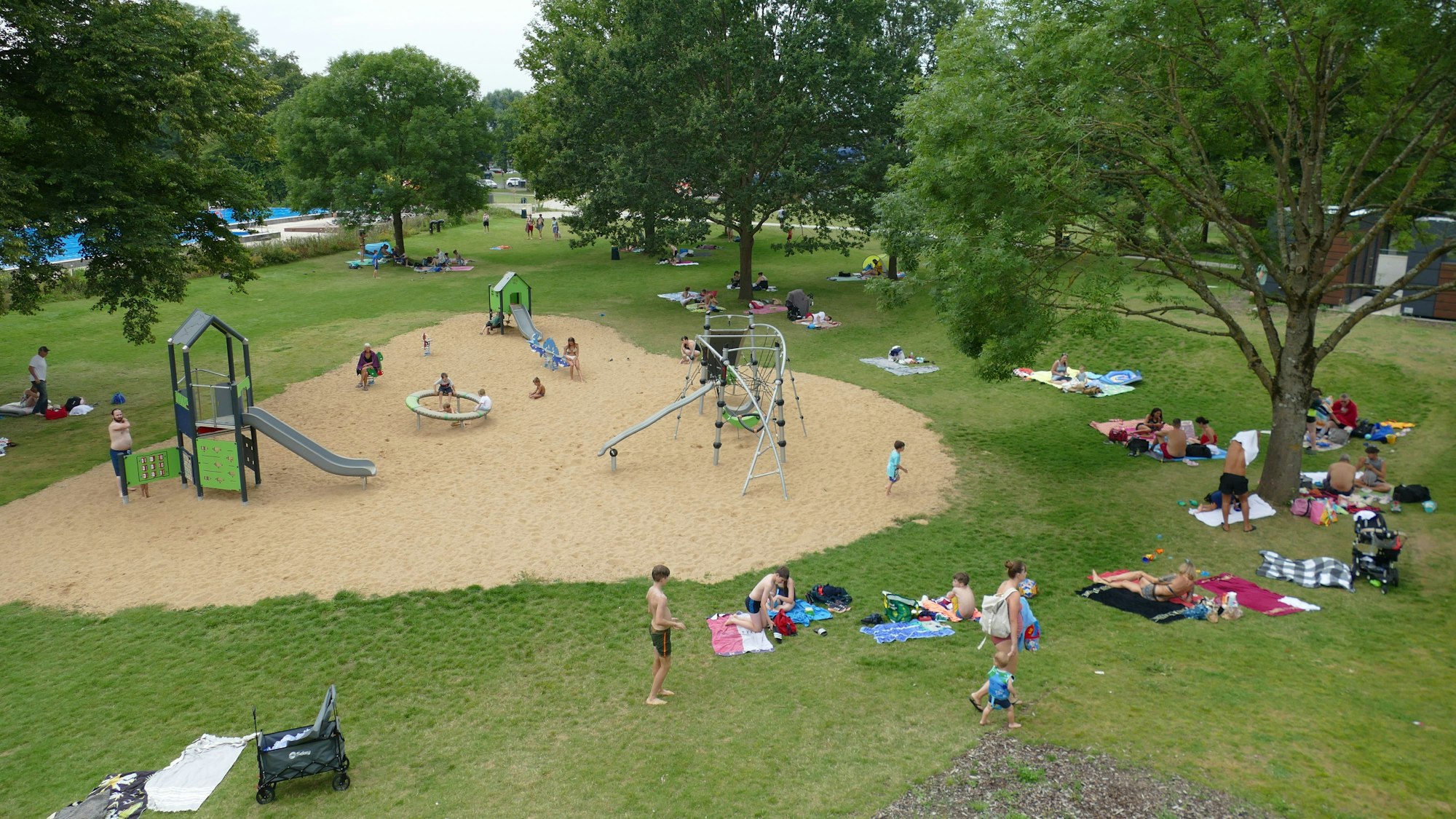 Menschen tummeln sich bei gutem Wetter auf der Freibadwiese im Aggua.