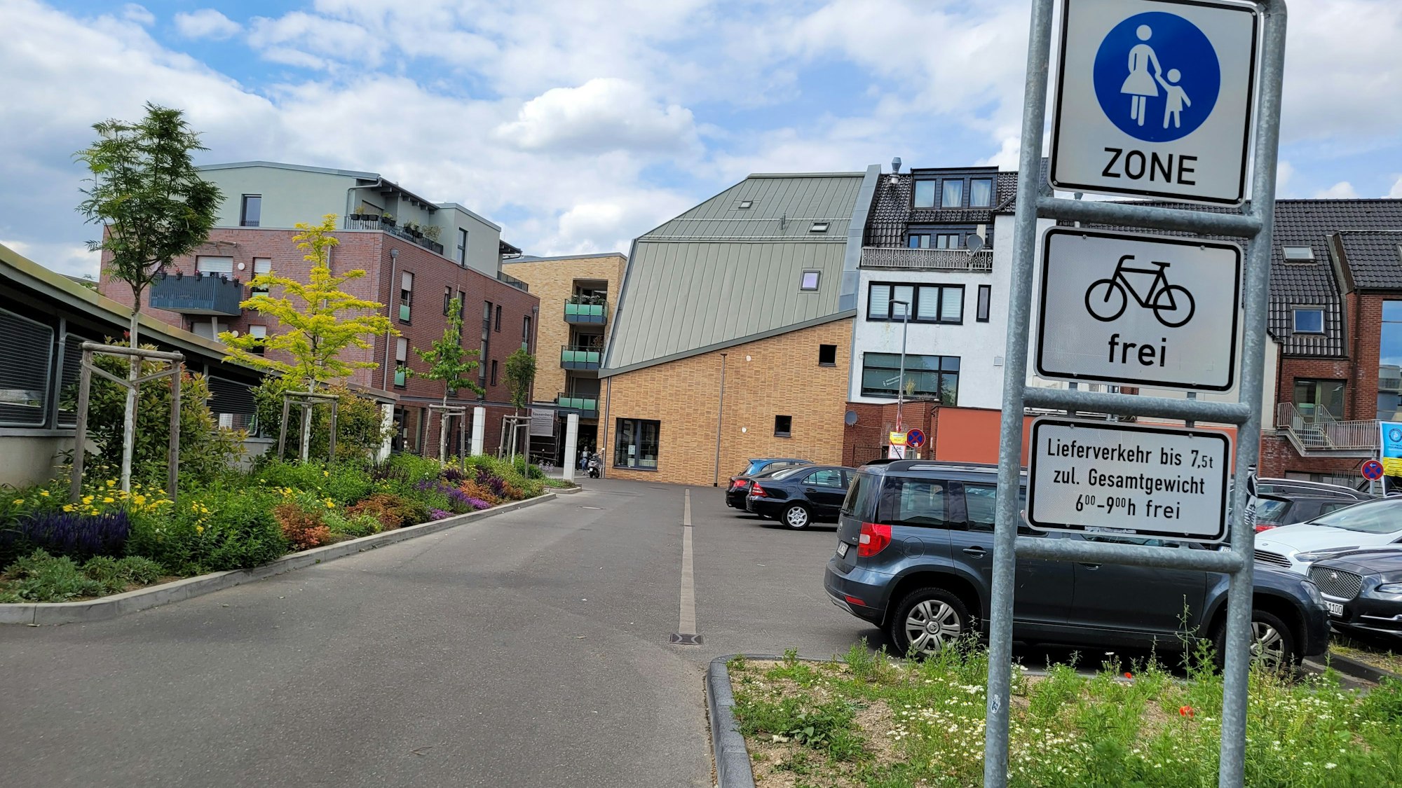 Links eine Straße, rechts Schilder, die auf die Fußgängerzone hinweisen.